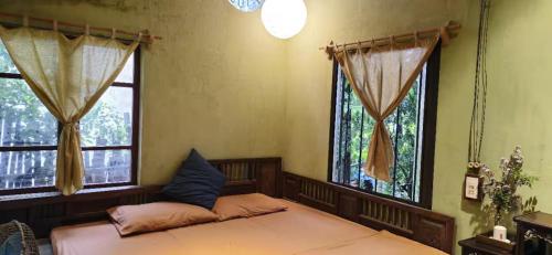 a bedroom with two beds and two windows at Yên homestay in Hoi An