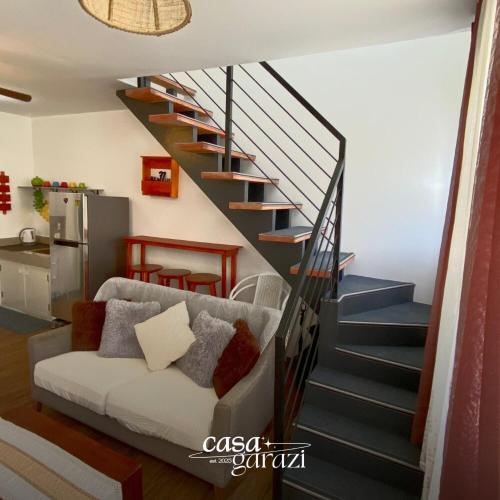 ein Wohnzimmer mit einer Couch und einer Treppe in der Unterkunft Casa Garazi in Calo