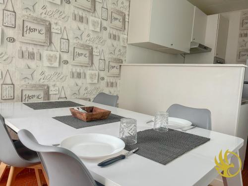 une cuisine avec une table et des chaises blanches et un mur dans l'établissement Pearl of Amiens center, Train station, Parking, à Amiens