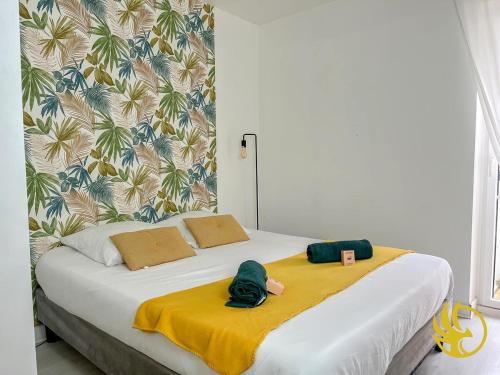 un lit avec deux animaux en peluche sur une couverture jaune dans l'établissement Pearl of Amiens center, Train station, Parking, à Amiens