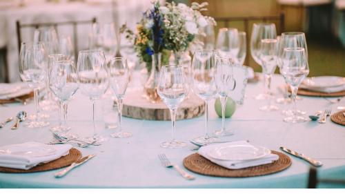 a table with wine glasses and plates and silverware at Radisson Blu Resort Visakhapatnam in Visakhapatnam
