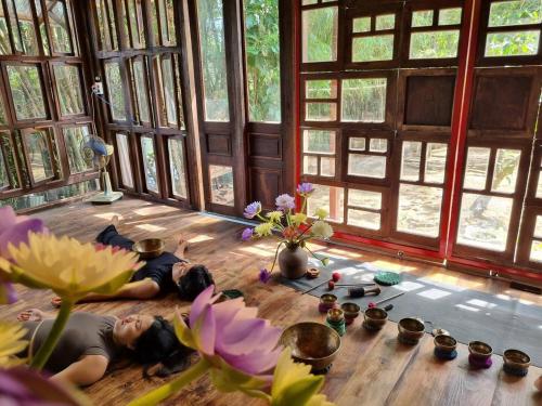 two children laying on the floor in a room with flowers at Yên homestay in Hoi An