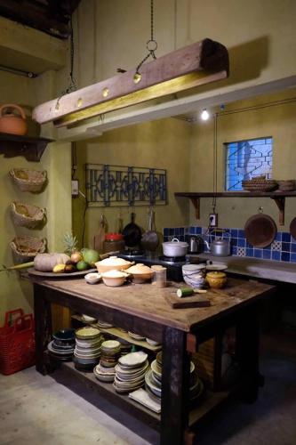 a kitchen with a table with plates and pans at Yên homestay in Hoi An