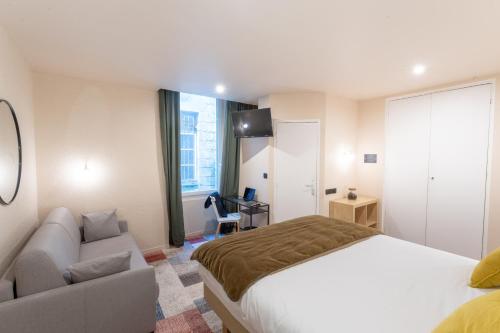 a hotel room with a bed and a couch at Résidence du Théâtre in Bordeaux