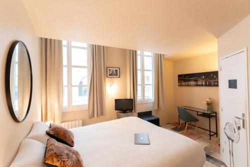 a hotel room with a bed and a couch at Résidence du Théâtre in Bordeaux