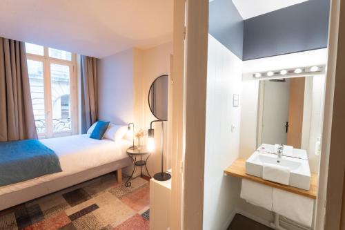a hotel room with a bed and a sink at Résidence du Théâtre in Bordeaux