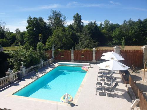 une piscine avec chaises et parasols dans une cour dans l'établissement Mobile Home sleeps 4, à Monsec