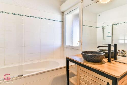 une salle de bain avec une baignoire et un lavabo dans l'établissement Duplex cosy à 200m de la plage, à Biscarrosse