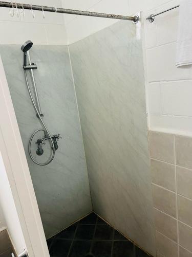 a shower stall in a bathroom with a tile floor at Ban Ban Springs Roadhouse and Motel in Dundarrah