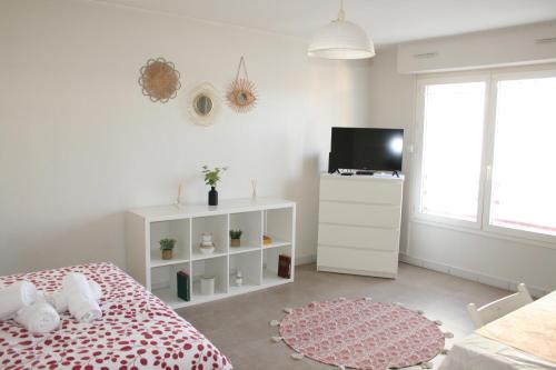 une chambre blanche avec un lit et une télévision dans l'établissement Studio cozy face à la gare, centre ville, wifi, à La Rochelle