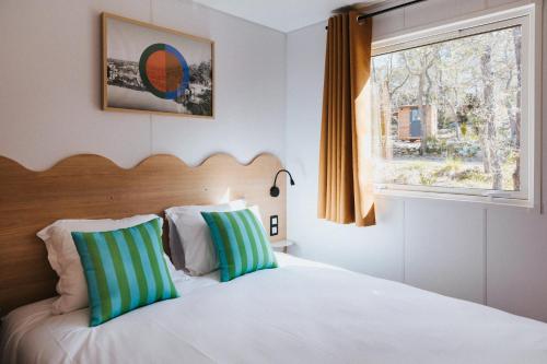 - une chambre avec un lit avec deux oreillers et une fenêtre dans l'établissement Camping Liberté Verdon, à Artignosc-sur-Verdon