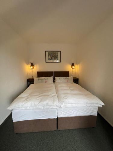 a bed in a bedroom with two lamps on it at Luxushütte Welgelegen in Bestwig