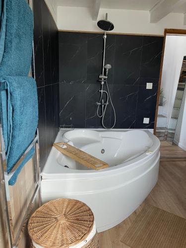 a white bath tub in a bathroom with blue towels at Logement Idéal pour un couple in Puisserguier