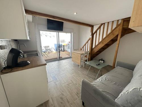 a kitchen and a living room with a couch at Superbe RDC terrasse centre ville clim wifi in Saintes-Maries-de-la-Mer