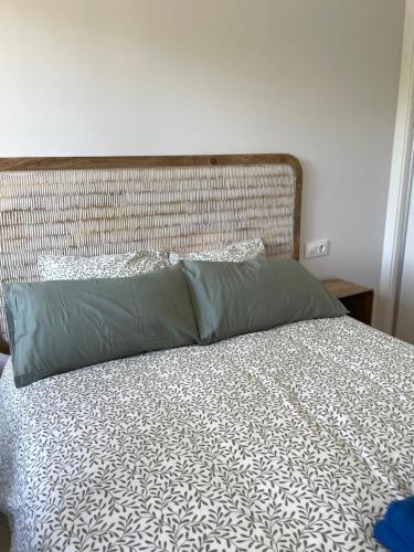 a bed with a headboard and two pillows on it at Apartamento a 400m de la playa en Ares, garaje incluído in Ares