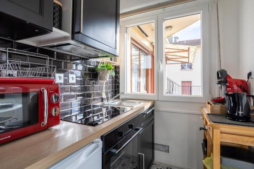 a kitchen with a red microwave and a counter at Appartement de charme, Maison des examens, Paris ligne 14 in Gentilly