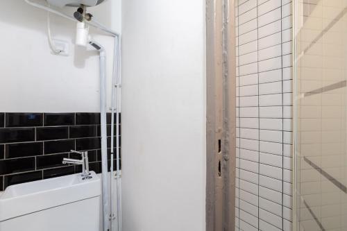 a bathroom with a shower and a white sink at Appartement de charme, Maison des examens, Paris ligne 14 in Gentilly