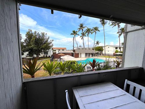 a balcony with a table and a view of a pool at Your Slice of Paradise in Kona - Walk to Beach and Stores in Kailua-Kona
