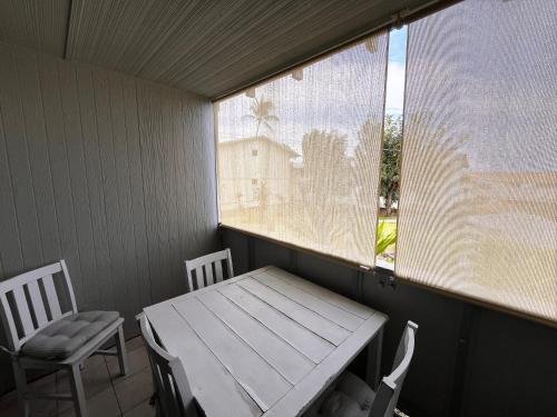 a table and chairs in a room with a window at Your Slice of Paradise in Kona - Walk to Beach and Stores in Kailua-Kona