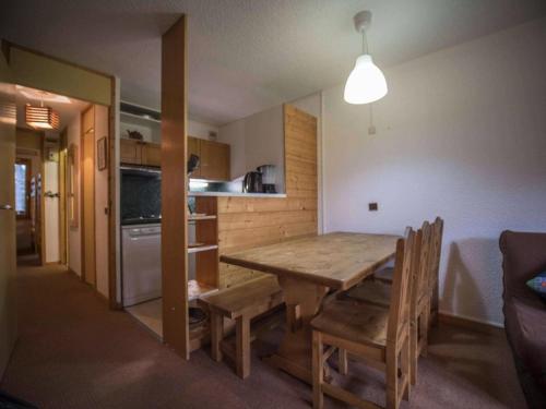 une cuisine et une salle à manger avec une table et des chaises en bois dans l'établissement Résidence Cheval Noir G - CHEVAL NOIR 33 MAE-6401, à Valmorel