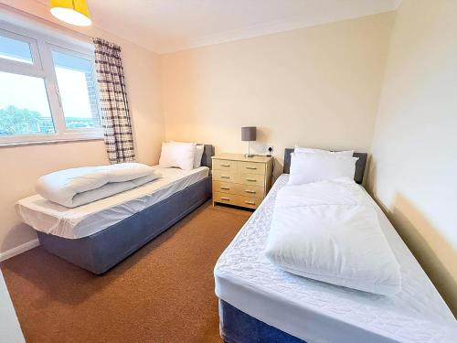 een slaapkamer met twee bedden en een raam bij Dog Friendly Chalet At Broadland Park And Marina In Lowestoft Ref 12027B in Lowestoft