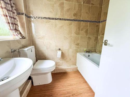 een badkamer met toilet, bad en wastafel bij Dog Friendly Chalet At Broadland Park And Marina In Lowestoft Ref 12027B in Lowestoft