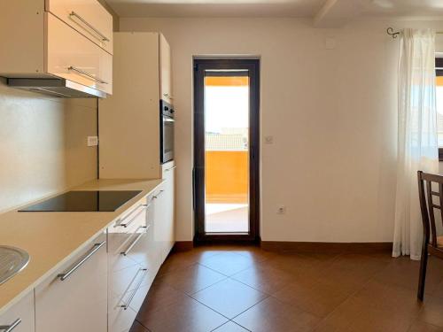 a kitchen with white cabinets and a door leading to a patio at Casa Sol Maris in Novigrad Istria