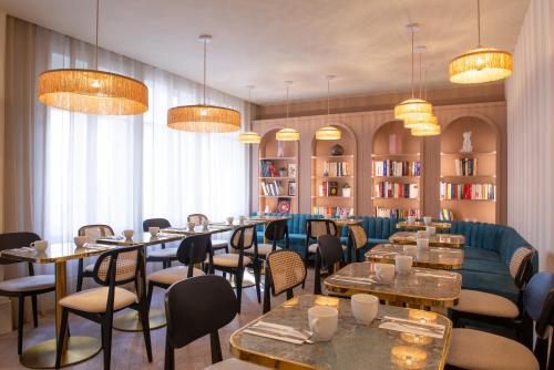 - un restaurant avec des tables, des chaises et un canapé dans l'établissement Mercure Paris Pigalle Sacre Coeur, à Paris