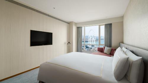 a hotel room with a large white bed and a window at InterContinental Suzhou Hotel by IHG in Suzhou