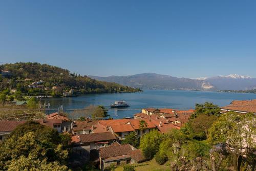 a river with a town and a boat in the water at appartamenti i fiori del lago in Laveno