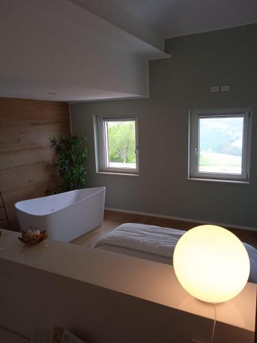 a large bathroom with a tub and a window at La Promessa in Santa Maria Nuova