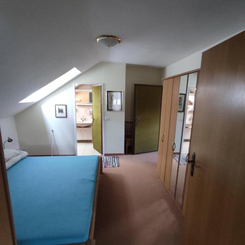 a room with a blue bed and a hallway at Haus Maria Bodensdorf in Tratten