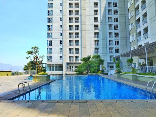 a swimming pool in front of a tall building at Apartment Skyland Jatinangor by Mustika in Cikeruh