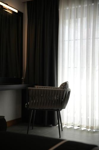 a chair sitting in front of a window at The Local House Alaçatı in Alacati