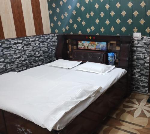 un letto in una stanza con avertisementatronatronstrazionstrationstrationstrationstration di Jai Nagraja Hotel & Restaurant, Yamnotri a Kharsālī