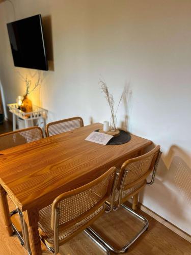 a wooden dining room table with chairs and a tv at Familien Animation Cafe Spielplätze Meerblick WLAN in Fanø