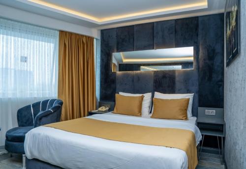 a hotel room with a large bed and a chair at 216 Silver Suite in Tuzla