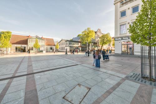 a group of people standing in the middle of a street at Monte Cassino 58 with City View by NorthSide Apartments in Sopot