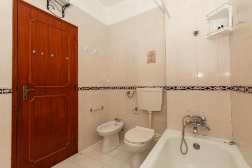 een badkamer met toilet, wastafel en bad bij Silence Ground-floor and Pool in Lagos