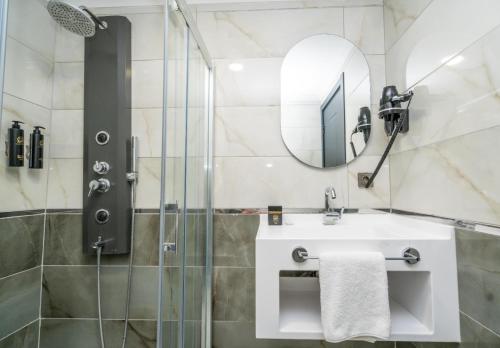 a bathroom with a shower and a sink and a mirror at 216 Silver Suite in Tuzla