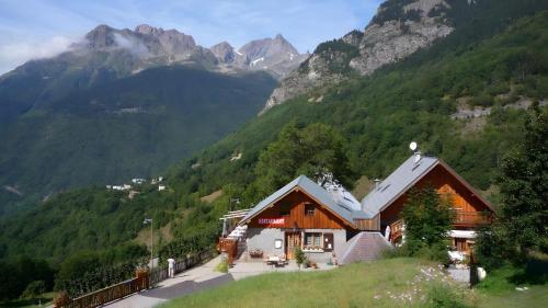 a house on a hill with mountains in the background at Chambre d'hôte Gite Passoud in Oz