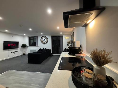 a living room with a couch and a clock on the wall at CroftCabin in Wolverhampton