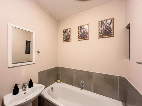 a bathroom with a white tub and a sink at The Ridge Modern Escape in Midrand