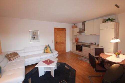 a living room with a white couch and a table at Seepension Neubacher KG in Nussdorf am Attersee