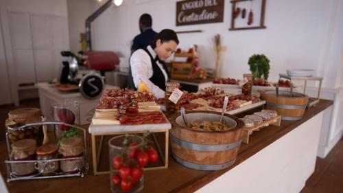 a woman preparing food at a buffet in a store at Altafiumara Resort & Spa in Villa San Giovanni