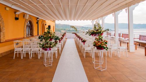 a row of tables and chairs with flowers on them at Altafiumara Resort & Spa in Villa San Giovanni