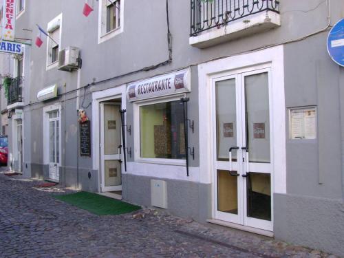 a building with doors and windows on a street at Residencia Paris in Coimbra