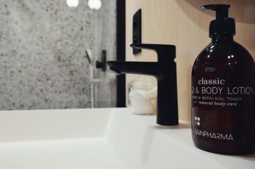 a bottle of soap sitting next to a bathroom sink at Cabin vr 4, zicht Semois-rivier! in Poupehan