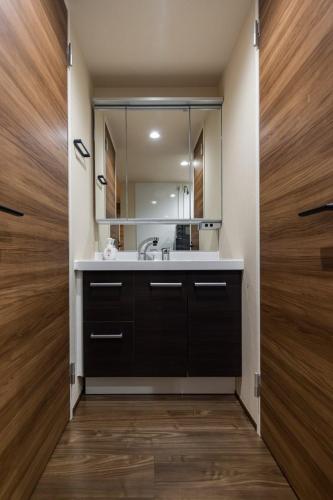 a bathroom with a sink and a mirror at Culture villa HANEDA in Tokyo