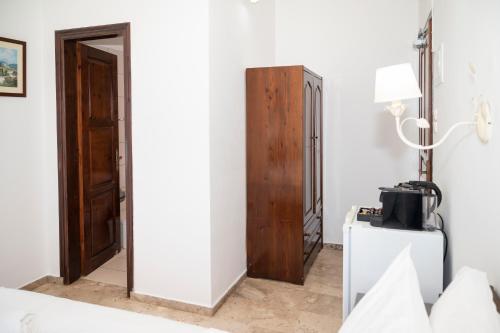 a room with a bed and a wooden cabinet at Argo Rooms-Papadakis in Kissamos